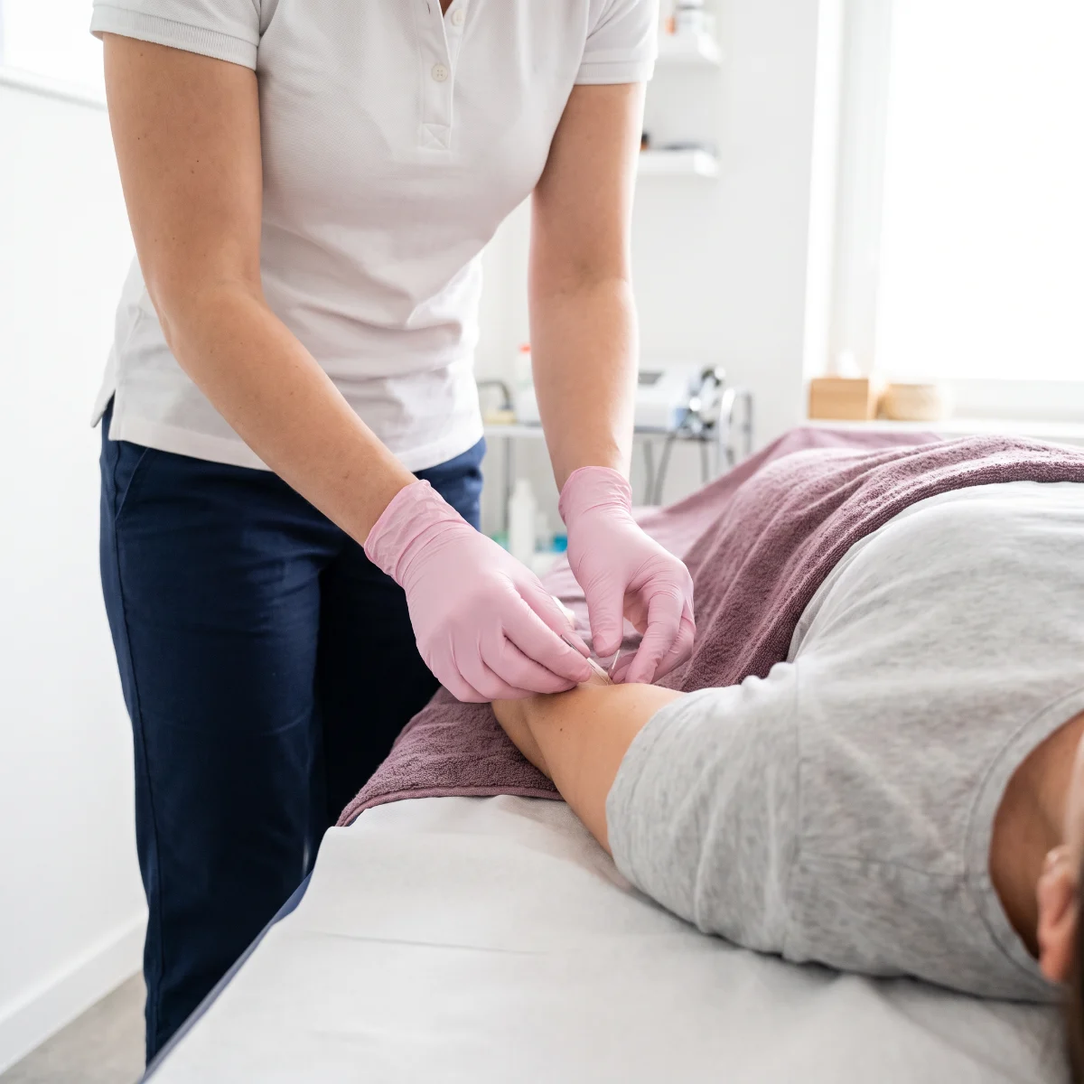 Fisioterapeuta aplicando una técnica de punción seca con aguja en la musculatura de la espalda de un paciente en Fisioespai Guinardó.