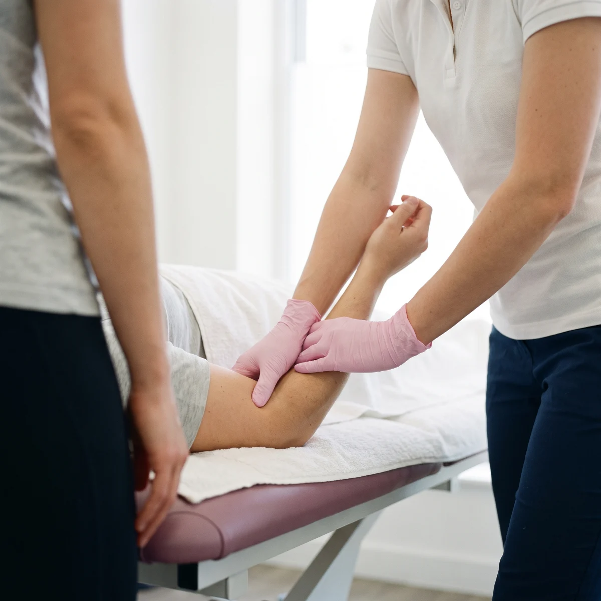 Fisioterapeuta pautando ejercicios de rehabilitación post-quirúrgica y trabajo de movilidad articular a un paciente en la consulta de Fisioespai Guinardó.